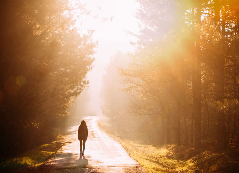 Person walking on sunlit path